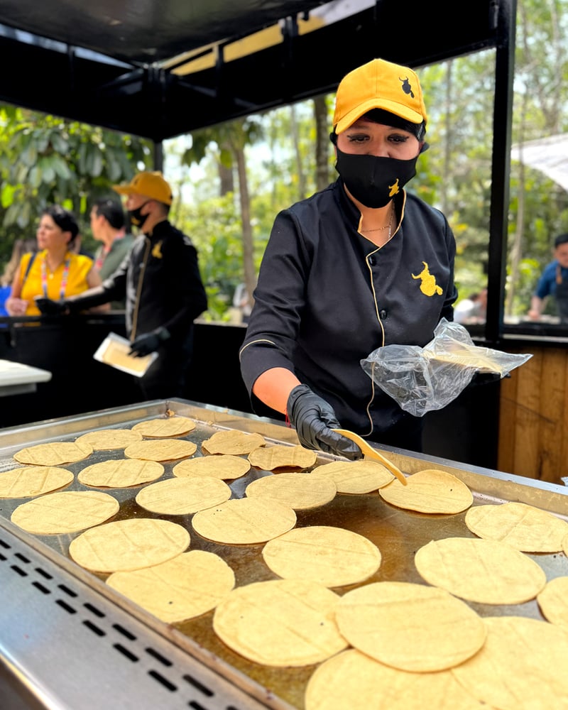 Taquero preparando tortillas en evento